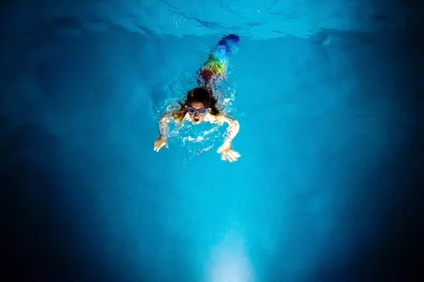 Syrena nurkowanie w kierunku światła niebieskiego basenu w nocy, z — Zdjęcie stockowe