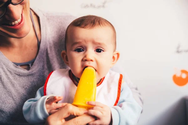 Bebé saboreando un helado de naranja . — Foto de Stock