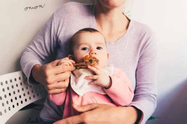 Bebé de 4 meses mordisqueando una pierna de pollo, probando sus primeros alimentos — Foto de Stock