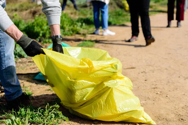 Voluntarios recogen basura plástica de un contaminado e natural — Foto de Stock