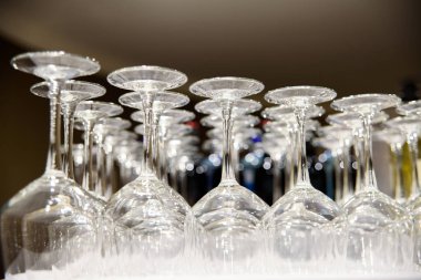 Empty wine glasses stacked on a barman's table, illuminated at n