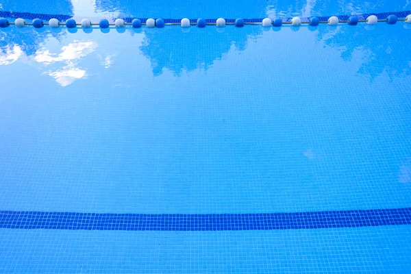 Detalle del agua de una piscina con balizas para separar el baño —  Fotos de Stock