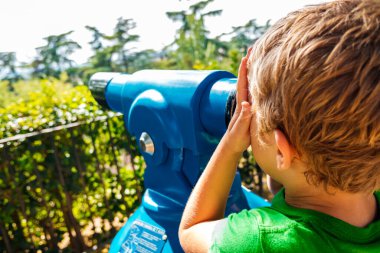Çocuk turistler için bir spyglass mavi gökyüzü bakarak.