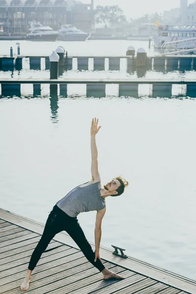 Trikonasana Yoga Duruşu Deniz Kenarındaki Bir Şehirde Genç Kızıl Saçlı — Stok fotoğraf