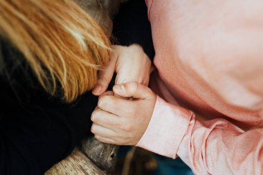 Nişanı sırasında birbirini seven iki çiftin birbirine dolanmış ellerinin ayrıntıları..