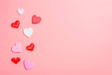 Aşk ve romantik kompozisyonlar için kırmızı kalpleri olan boş pembe bir zemin..