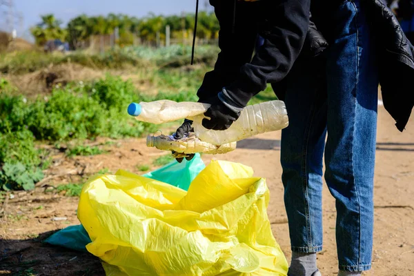 ボランティアは汚染された自然環境からプラスチックごみを収集し 袋に入れて保管します — ストック写真