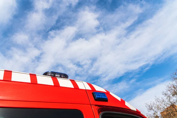 Red ambulance detail during the day with sky in the background, medical concept.