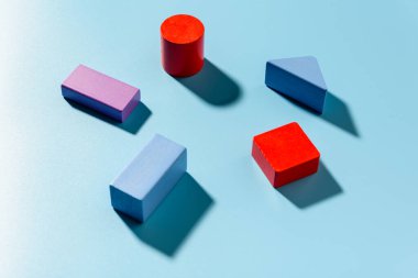 Kırmızı geometrik şekillere sahip mavi arkaplan basit bir kompozisyonda gölgeler oluşturur.