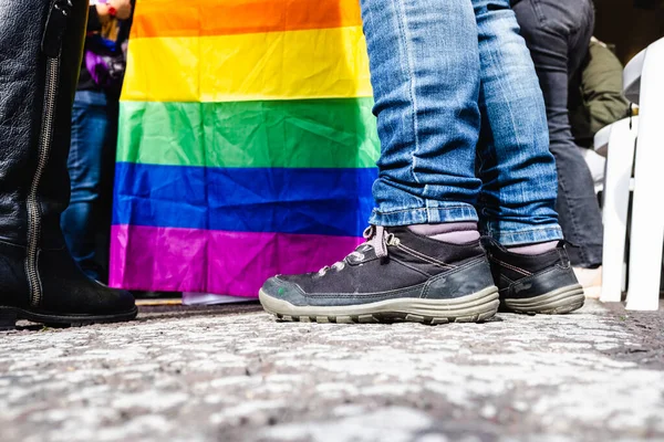 大都市の路上で抗議デモ行進中に平等の権利を主張するLgbt集団の旗と一緒に歩いている人々のグループ — ストック写真