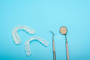 Mavi arka planda izole edilmiş diş doktorları tarafından kullanılan diş hizalayıcısı.