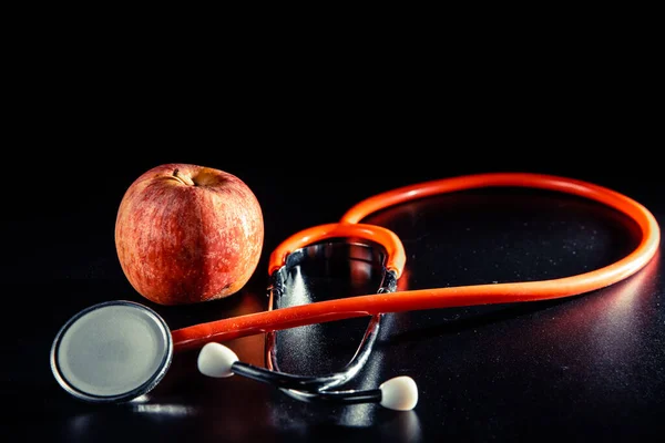 Μαύρο Φόντο Μήλο Και Στηθοσκόπιο Έννοια Των Καρδιαγγειακών Προβλημάτων — Φωτογραφία Αρχείου