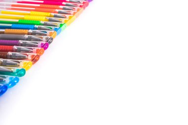 İzole edilmiş kopya alanı olan beyaz bir stüdyo masasına dizilmiş renkli kalemler..