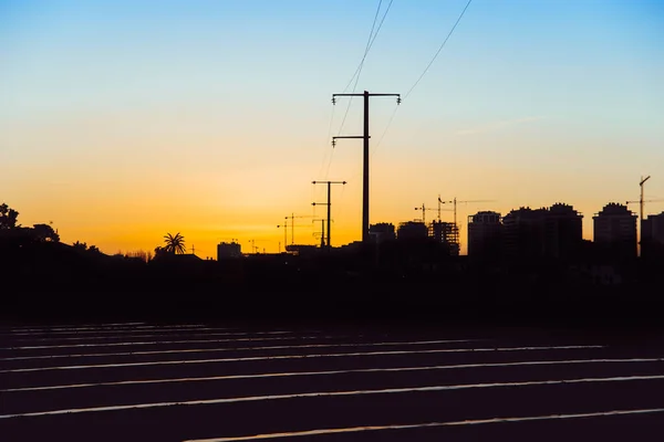 城市附近田里黄昏时分的电塔 — 图库照片