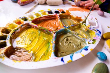 Akrilik boyayla resim yapan bir kız sanat okulunda yaratıcılığını geliştiriyor..