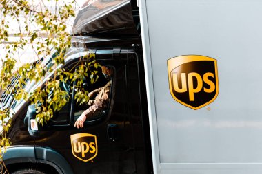 Valencia, İspanya - 7 Nisan 2020: UPS kurye şirketinin kamyon şoförü aracın içinde maske takıyor, teslimat günü covid-19 salgınının ortasında.