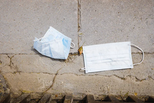 surgical masks dumped as garbage on the street by coronavirus bystanders.