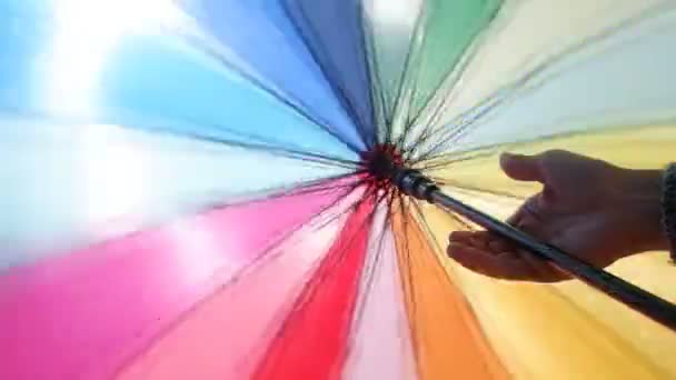 Womans Hand Holds Spins Brightly Colored Umbrella — Stock Video