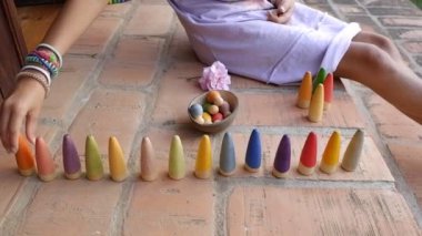 Küçük kız sembolik montessori oyununu ve hayal gücünü geliştirmek için tahta bloklarla oynuyor.