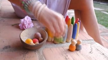 Küçük kız sembolik montessori oyununu ve hayal gücünü geliştirmek için tahta bloklarla oynuyor.