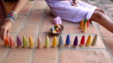 Küçük kız sembolik montessori oyununu ve hayal gücünü geliştirmek için tahta bloklarla oynuyor.