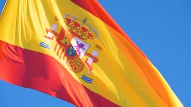 Ulusal İspanyol bayrağı güneşli bir günde rüzgarda dalgalanıyor.