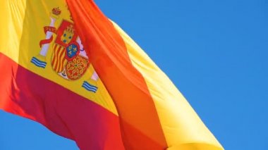 Ulusal İspanyol bayrağı güneşli bir günde rüzgarda dalgalanıyor.