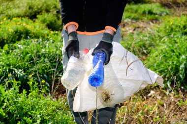 Kirlenmiş alanı plastik şişelerden temizleyen ekolojik gönüllüler.