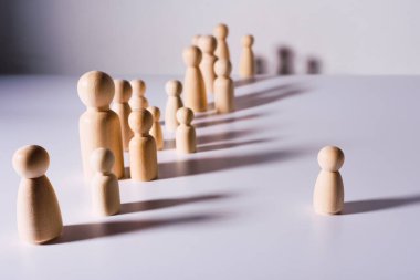 Sosyal uzaklık, beyaz arka planda birbirinden izole ahşap figürlerle sembolize edilir..