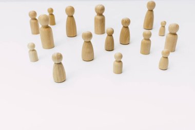 Ahşap figürler tarafından temsil edilen kafası karışmış bir grup insan, beyaz arka plandaki stüdyoda izole edilmiş..