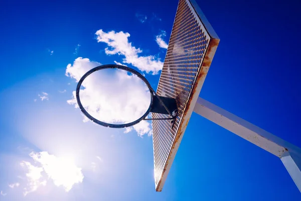 Basketbalmandje Een Buitenveld Met Een Intense Zon Met Donkerblauwe Wolkenlucht — Stockfoto