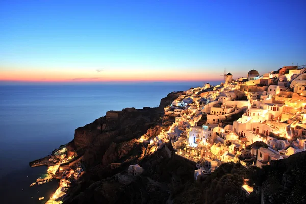 Belysta byn Oia i solnedgången på ön Santorini Grekland — Stockfoto