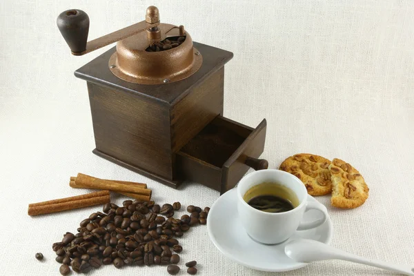 Tasse à café, biscuit, broyeur et grains de café sur la table — Photo