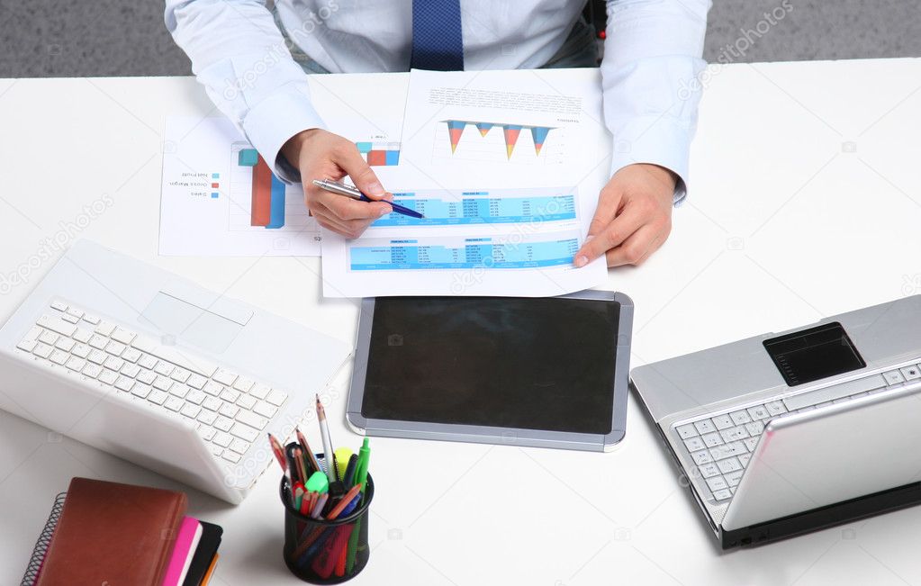 Business man sitting on the desk and working in office