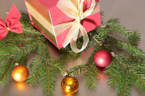 Weihnachtskomposition mit Geschenkbox und hellen, roten Kugeln auf Holztisch — Stockfoto