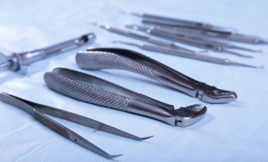 Dört farklı paslanmaz çelik cerrahi forseps ve beyaz arka plan üzerinde izole neşter yakın çekim