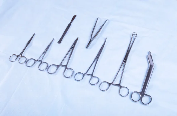 Close up van vier verschillende RVS chirurgische pincet en scalpel geïsoleerd op witte achtergrond — Stockfoto