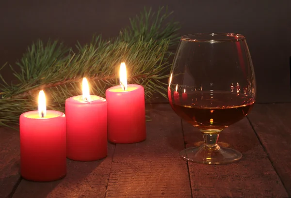 Weihnachtskomposition mit Glas-Cognac, Geschenkbox und Kerze auf Holztisch — Stockfoto