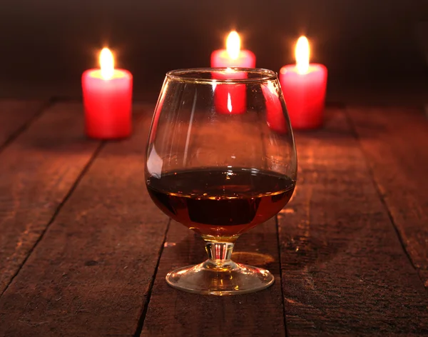 Kerst samenstelling met glas cognac, de doos van de Gift en de kaars op houten tafel — Stockfoto