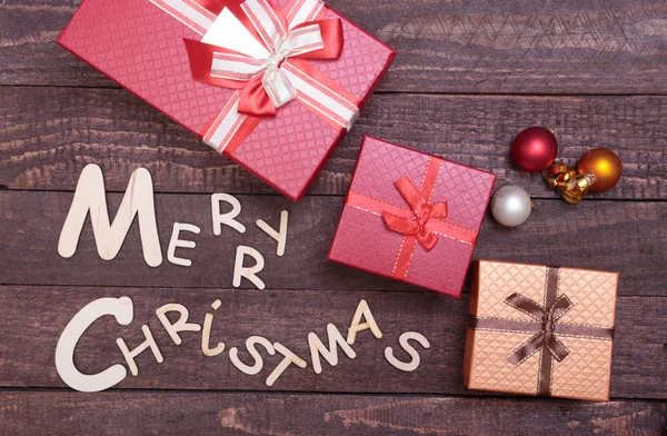 Kerst collectie, geschenken box, boom en decoratieve bal, op houten achtergrond. — Stockfoto