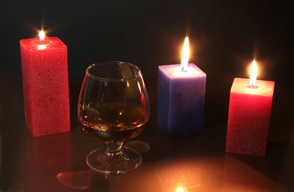 Kerst foto cognac glas en kaars op zwarte achtergrond — Stockfoto