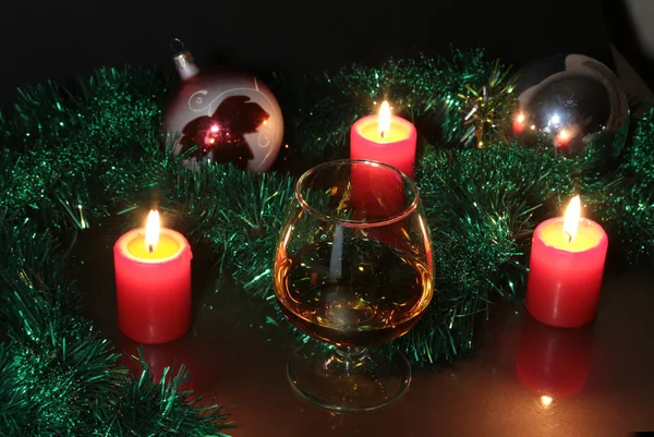 Christmas photo cognac glass and candle on black background — Stock Photo, Image