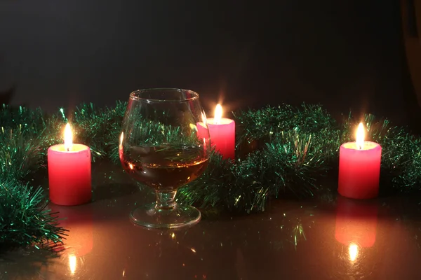 Weihnachten Foto Cognacglas und Kerze auf schwarzem Hintergrund — Stockfoto