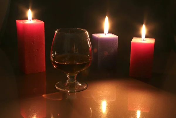 Kerst foto cognac glas en kaars op zwarte achtergrond — Stockfoto