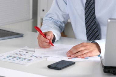 Laptop ile masada oturan ve ofiste germe neşeli genç işadamı