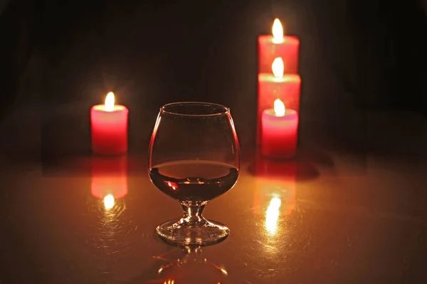 Weihnachtskomposition Foto Cognacglas und Kerze auf schwarzem Hintergrund — Stockfoto