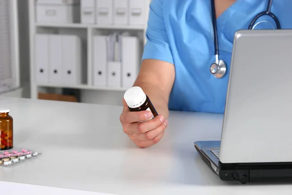 여성 의사 손에 약 병을 들고와 처방전을 쓰기의 클로즈업 보기. 의료, 의료 약 학 개념 — 스톡 사진