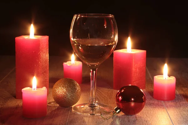 Glas Cognac und rote Kerze auf Holzgrund — Stockfoto
