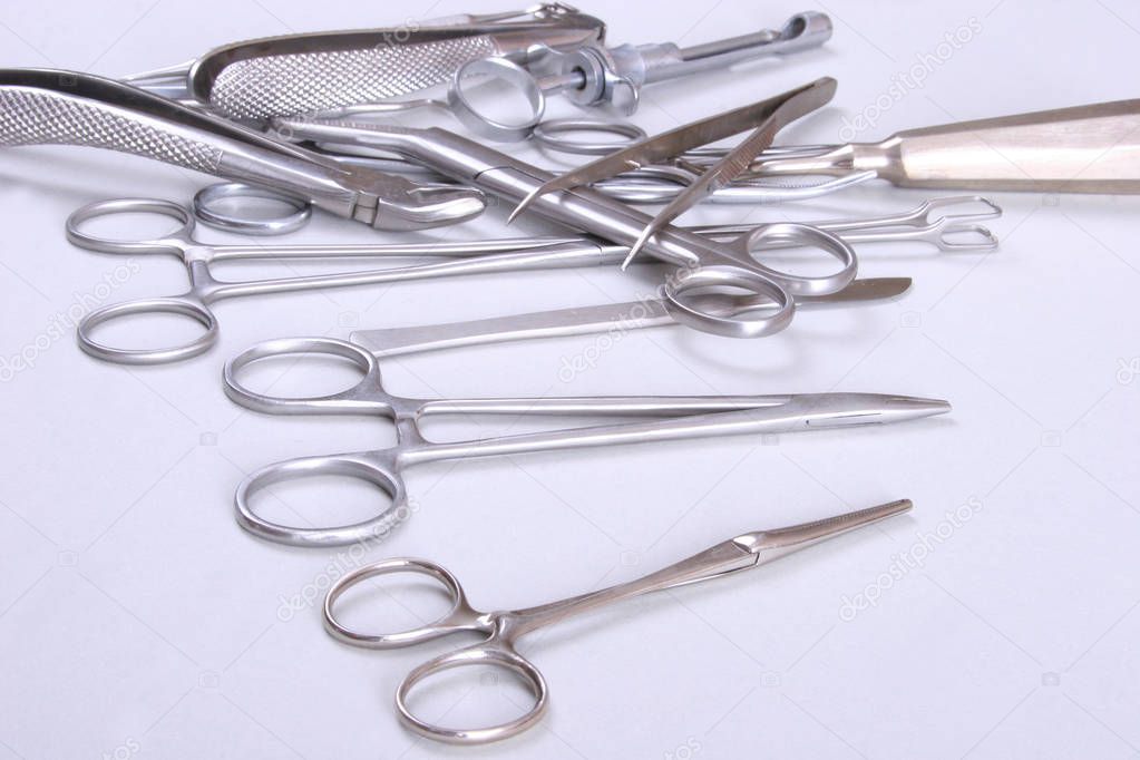 surgical instruments and tools including scalpels, forceps  tweezers arranged on a table for  surgery