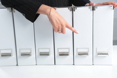 veri dosyaları bağlayıcı raflar arka planda tutan iş kadınları